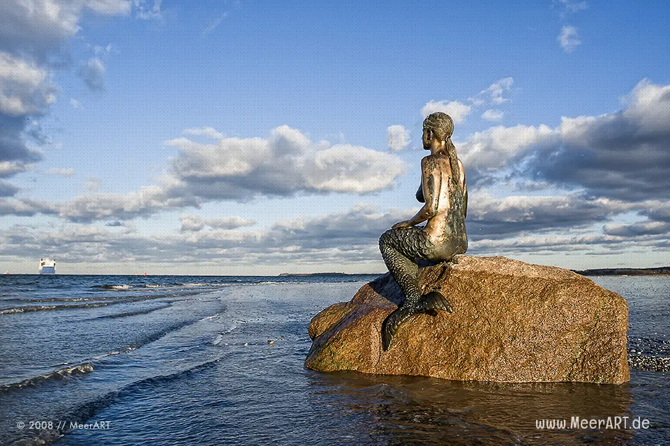 Travemünder Meerjungfrau auf einem Stein am Strand // Foto: MeerART