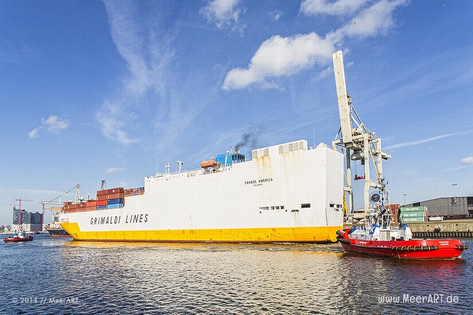 Das RoRo/ConRo-Schiff „GRANDE AMERICA“ (IMO: 9130937, Baujahr: 1997, BRZ: 56642, Tragfähigkeit: 27965 t, Container: 1321 TEU) wird von zwei Schlepper auf seinem Liegeplatz in den Hansahafen in Hamburg manövriert.