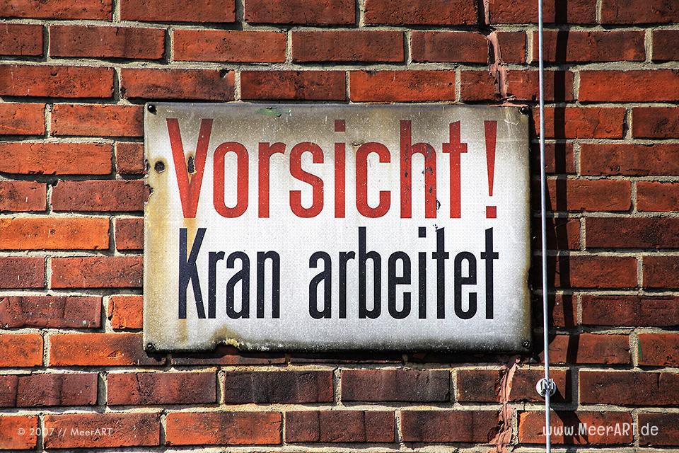 Warnschild im Hansahafen mit der Aufschrift "Vorsicht Kran" // Foto: MeerART