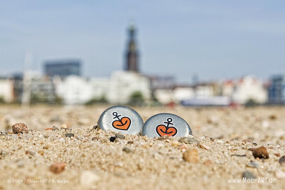 Zwei Astra-Kronkorken am Strand im Hamburger Hafen // Foto: R. Kerpa