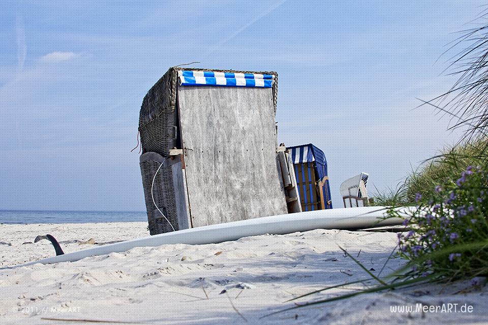Strandkörbe und ein Surfbrett am Strand von Schönberg/Kalifornien an der Ostsee // Foto: MeerART