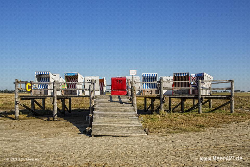 Eine Holzplattform mit Strandkörben an einem Strandabschnitt an der Nordsee in St. Peter-Ording // Foto: MeerART