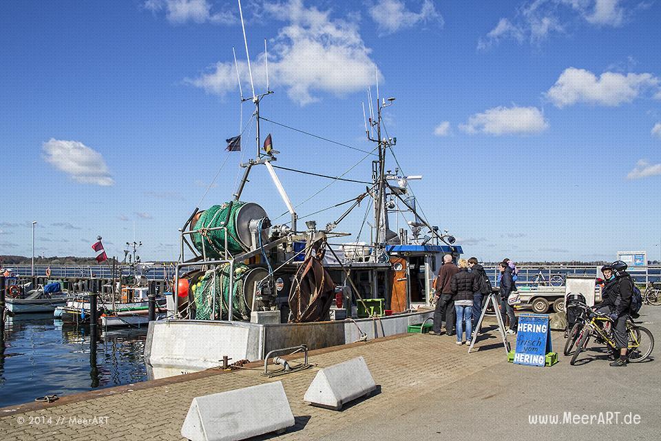 Ein Fischer verkauft fangfrischen Fisch direkt vom Fischkutter an seine Kunden im Hafen von Heikendorf/Möltenort // Foto: MeerART