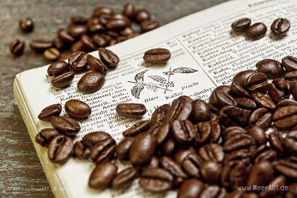 Ein altes aufgeschlagenes Lexikon mit Kaffeebohnen auf einem Holztisch // Foto: R. Kerpa